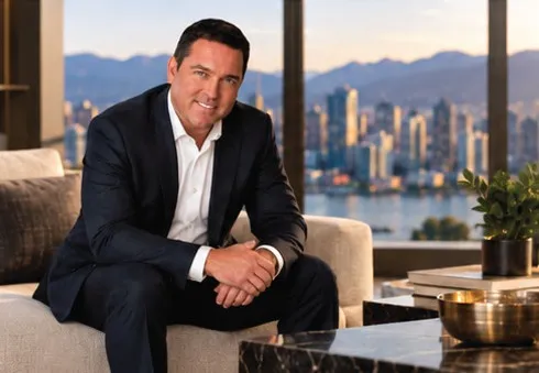 Chris Lotoski seated in a living room overlooking downtown Vancouver